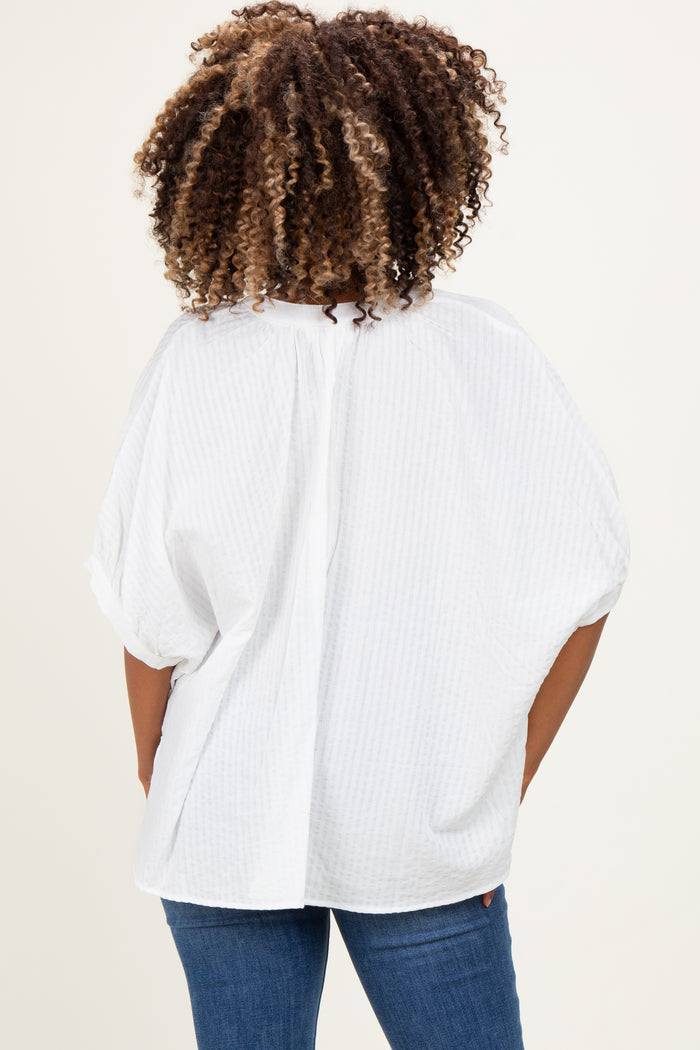 woman wearing a white short sleeve maternity top with a loose fit and a pleated back, viewed from the back