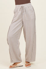 woman wearing beige and white striped wide-leg pants with a drawstring waist and side slits