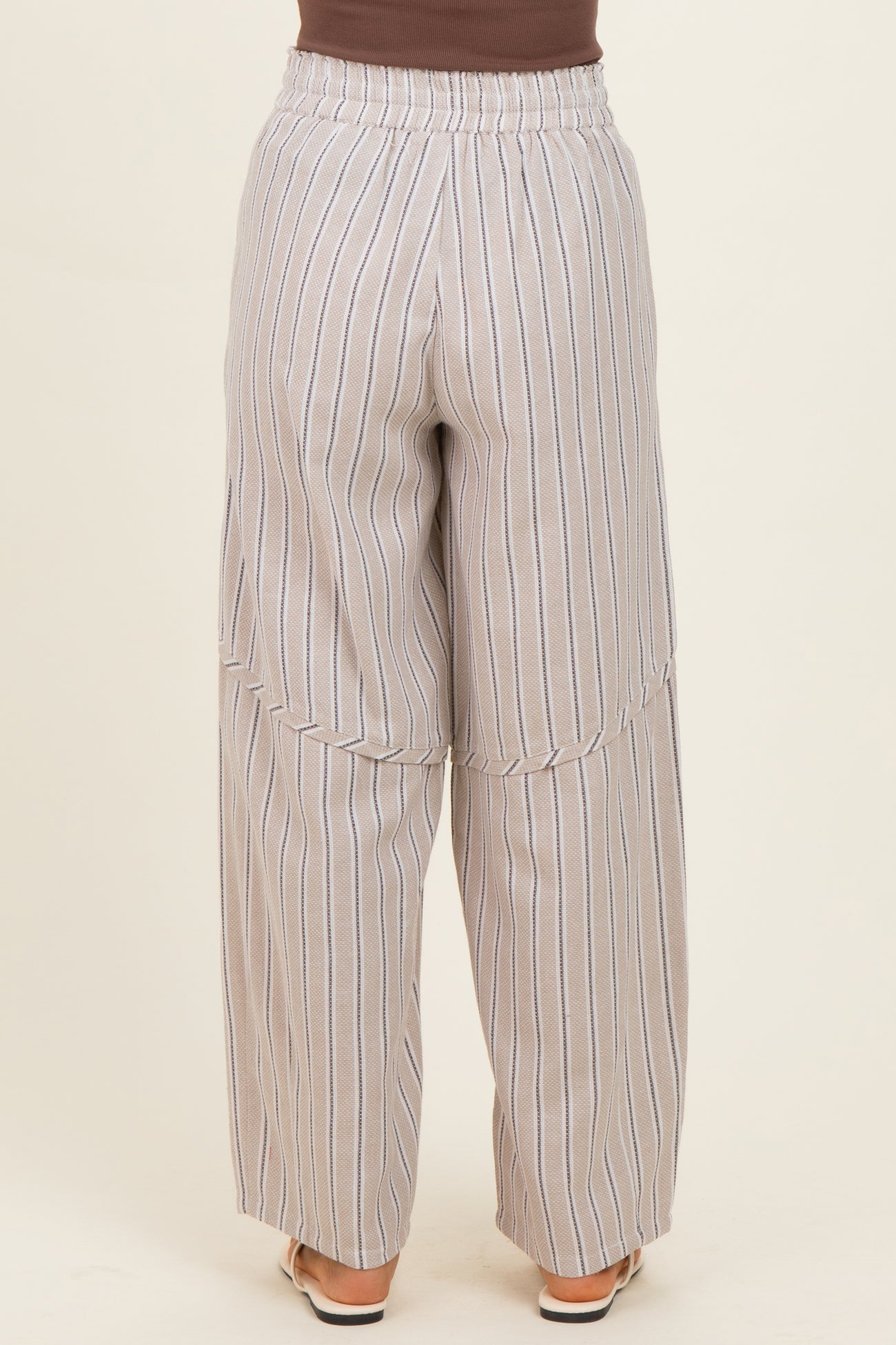 woman wearing light gray wide-leg striped pants with an elastic waistband, viewed from the back