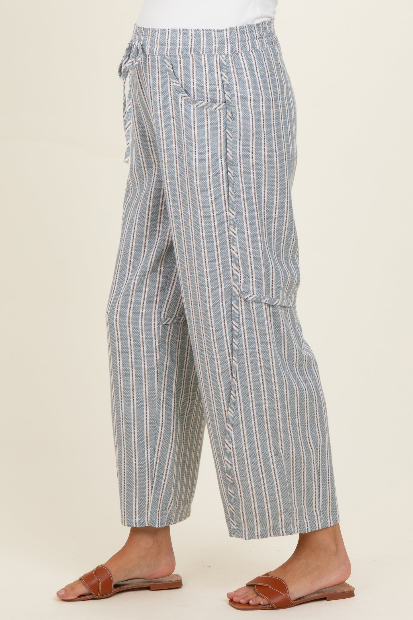 woman wearing gray and white striped maternity pants with a relaxed fit and side pockets