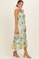 woman wearing a floral print midi dress with tie straps and a smocked bodice, paired with beige heels