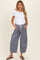 woman wearing a white short sleeve top and blue striped maternity pants with an elastic waistband and pockets
