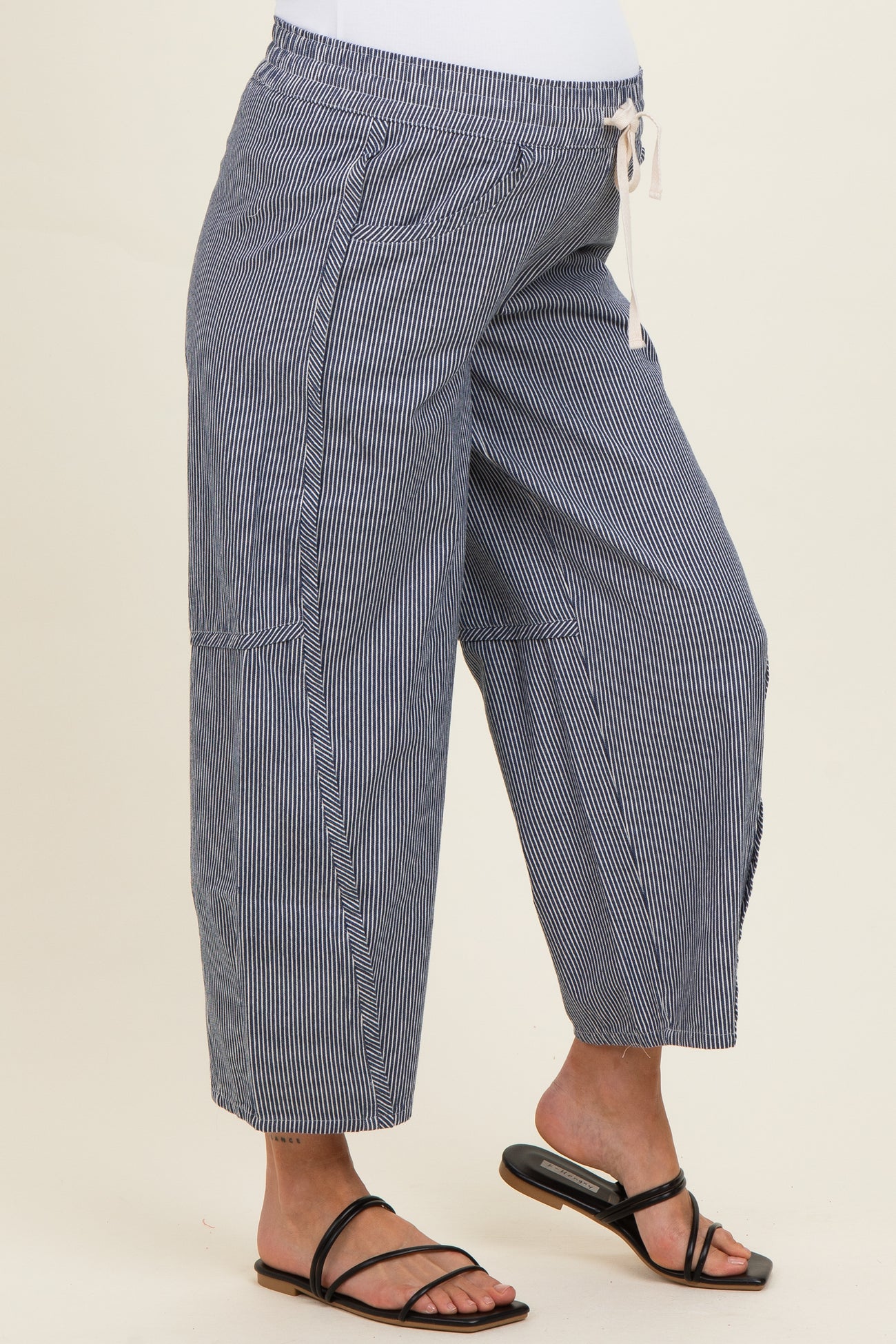 woman wearing navy and white striped maternity palazzo pants with a drawstring waist and side pockets