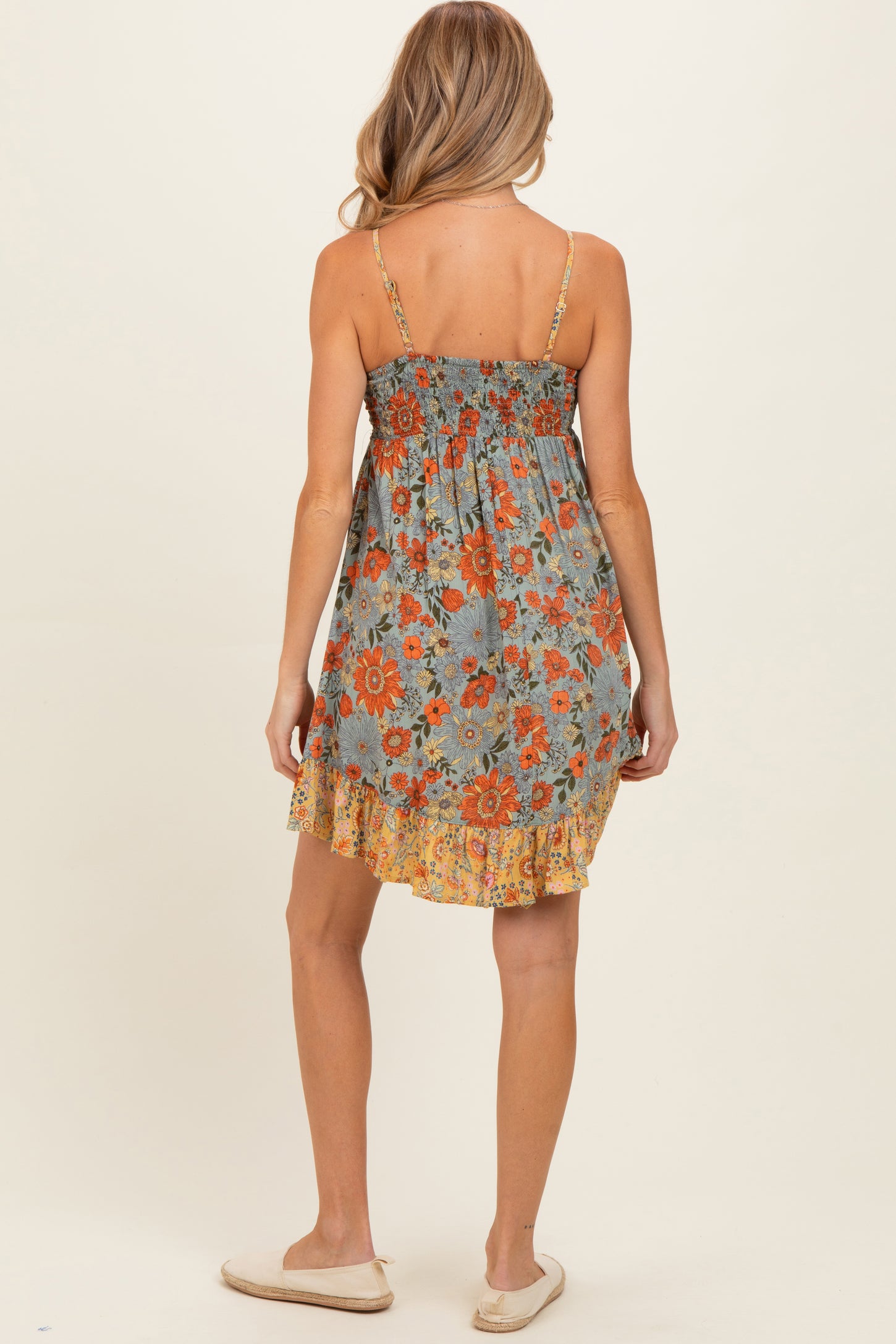 woman wearing a floral maternity sundress with smocked back and ruffle hem, showing a relaxed fit and adjustable straps