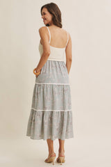 woman wearing a backless floral tiered maxi dress with a fitted bodice and spaghetti straps