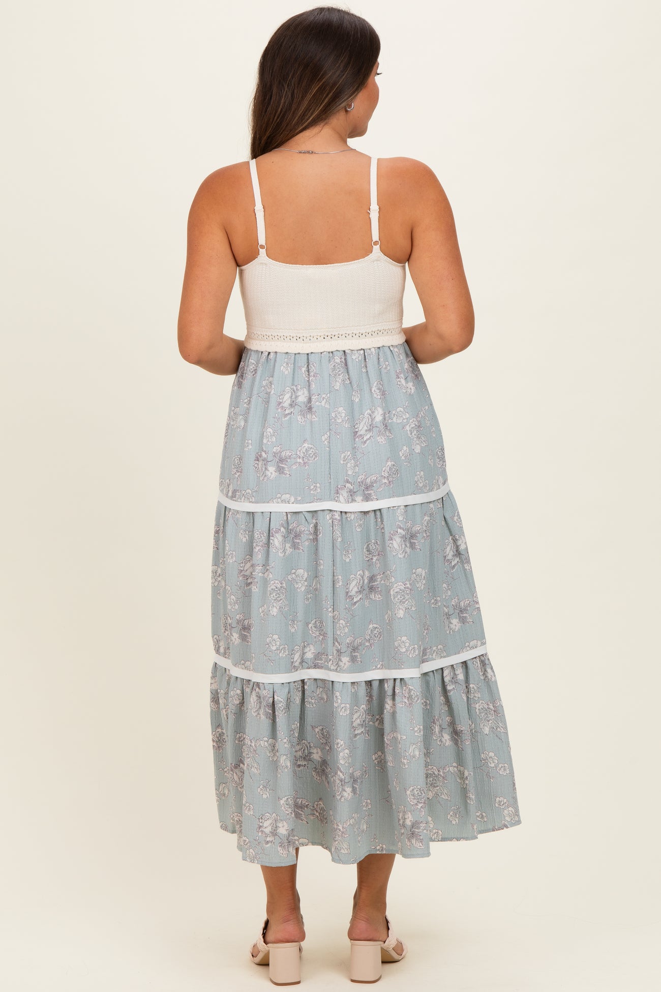 woman wearing a light blue floral maternity maxi dress with tiered design and a smocked bodice