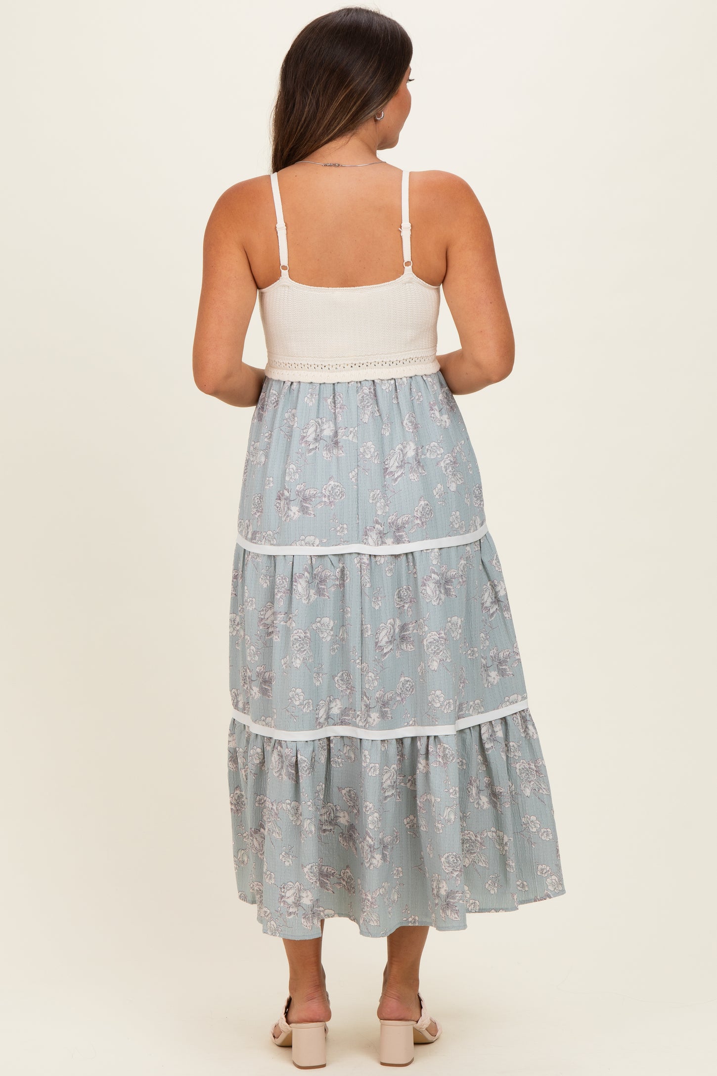 woman wearing a light blue floral maternity maxi dress with tiered design and a smocked bodice