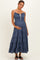woman wearing a dark blue tiered maternity dress with a drawstring neckline and holding her baby bump