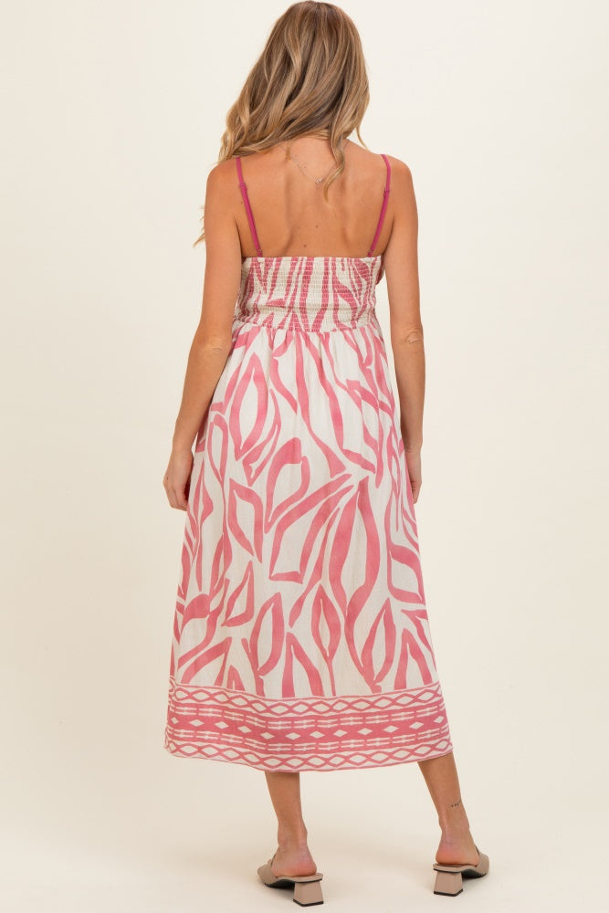 woman wearing a pink and white patterned maternity dress with a smocked back and spaghetti straps