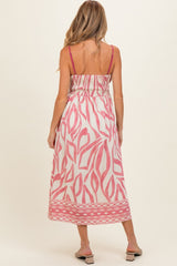 woman wearing a pink and white patterned maternity dress with a smocked back and spaghetti straps
