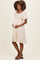 woman wearing a cream floral maternity dress with short puff sleeves and holding her baby bump