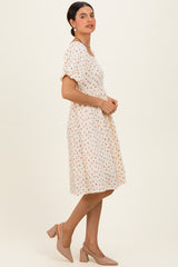 woman wearing a white short sleeve floral dress with a flared skirt and beige heels