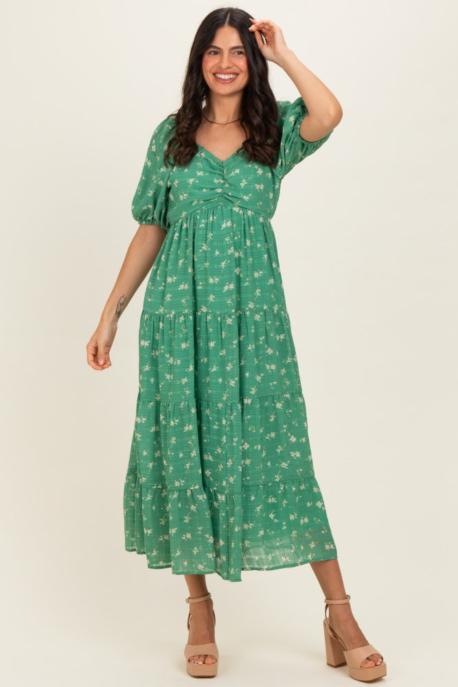 woman wearing a green floral maxi dress with puff sleeves and a tiered skirt