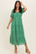 woman wearing a green floral maxi dress with puff sleeves and a tiered skirt