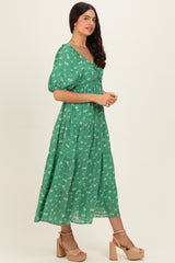 woman wearing a green floral puff sleeve maxi dress with a tiered skirt and tan block heel sandals