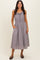 woman wearing a gray and white striped midi dress with ruffle details and pockets