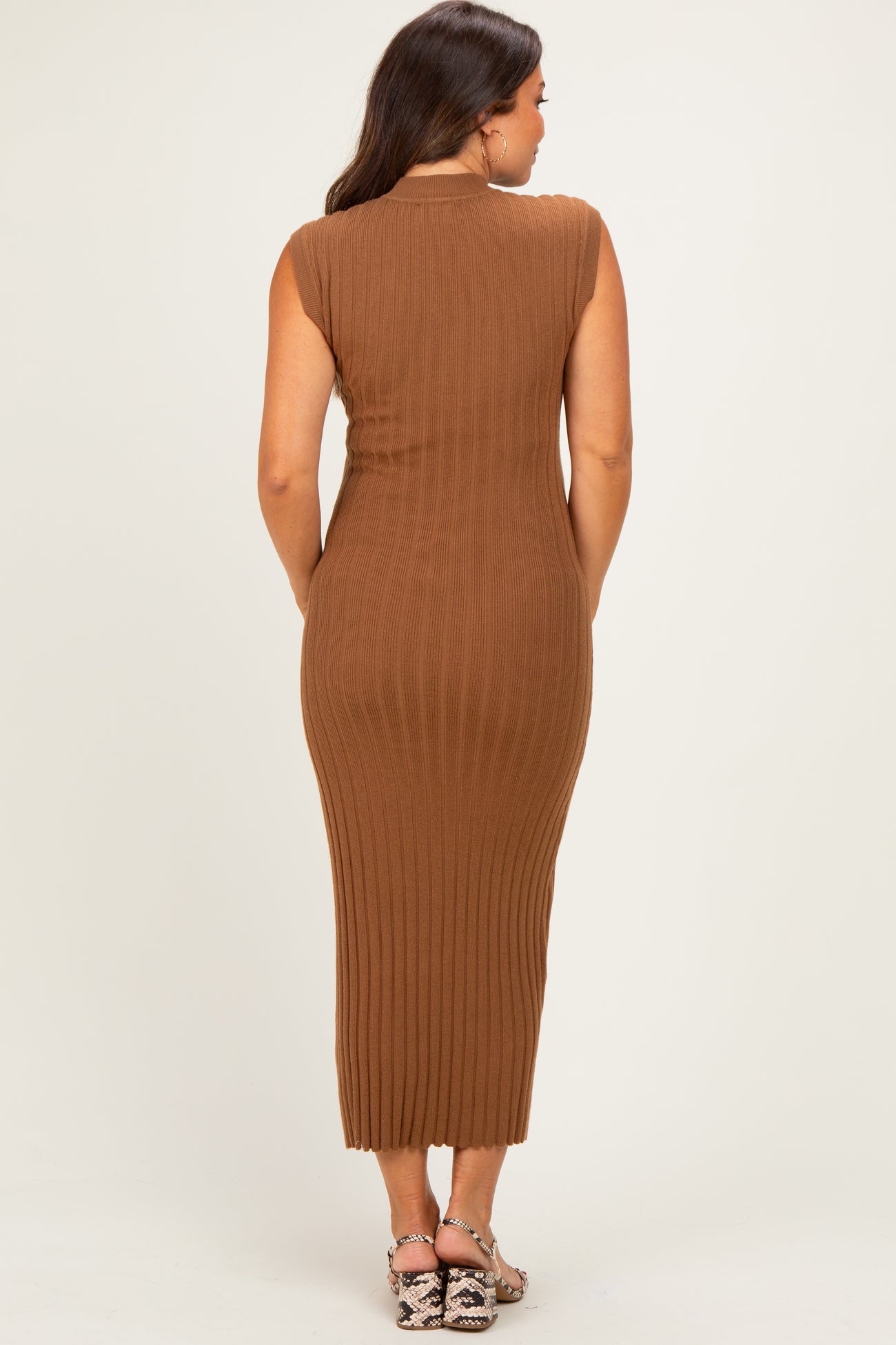 woman wearing a brown sleeveless ribbed maternity dress, showcasing a form-fitting silhouette from the back