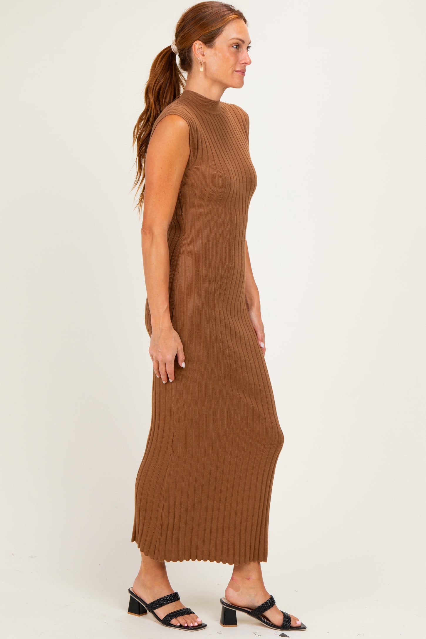 woman wearing a brown ribbed sleeveless maxi dress with a fitted silhouette and low neckline