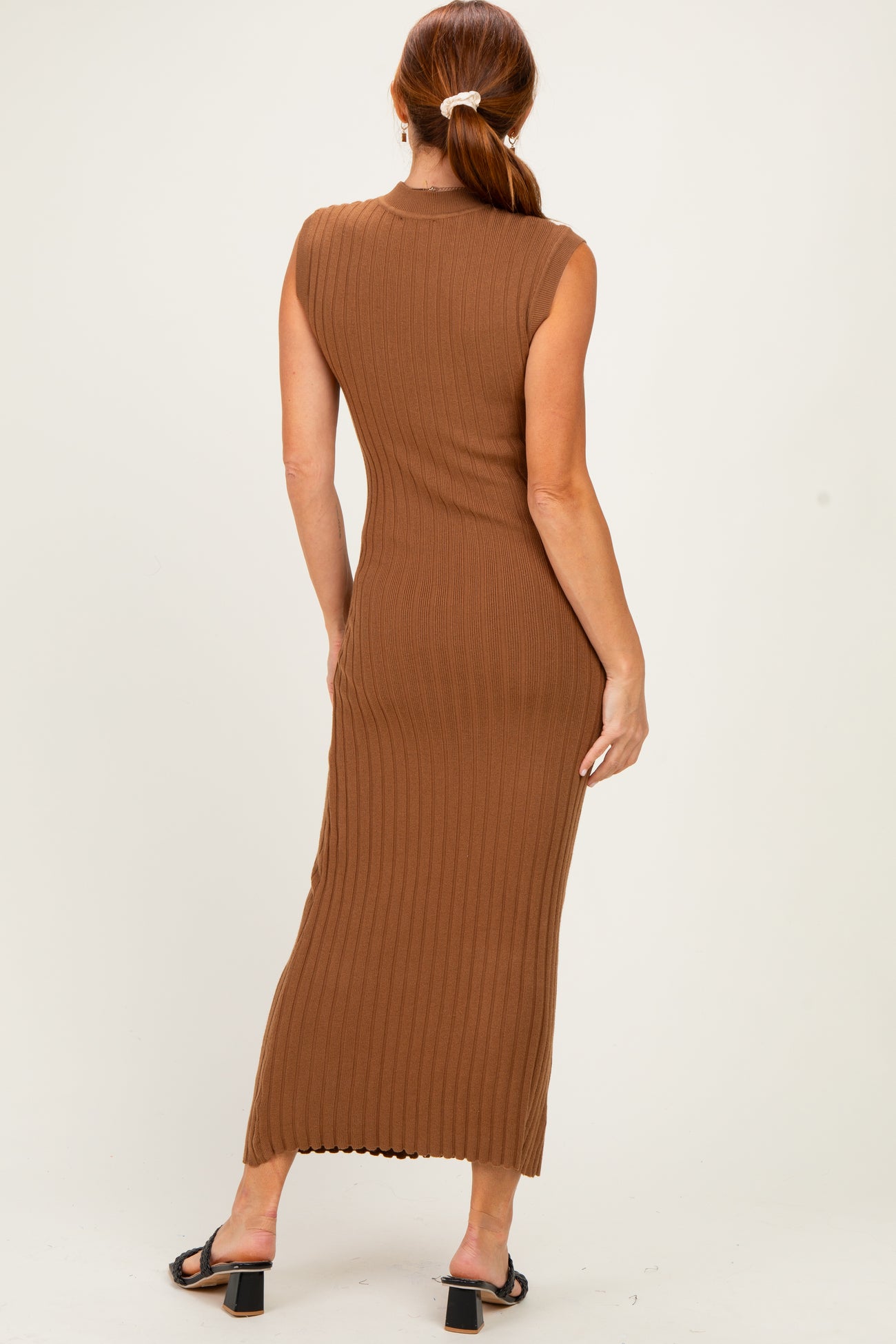 woman wearing a fitted brown ribbed maxi dress with no sleeves, viewed from the back
