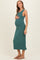woman wearing a teal sleeveless maternity dress and holding her baby bump