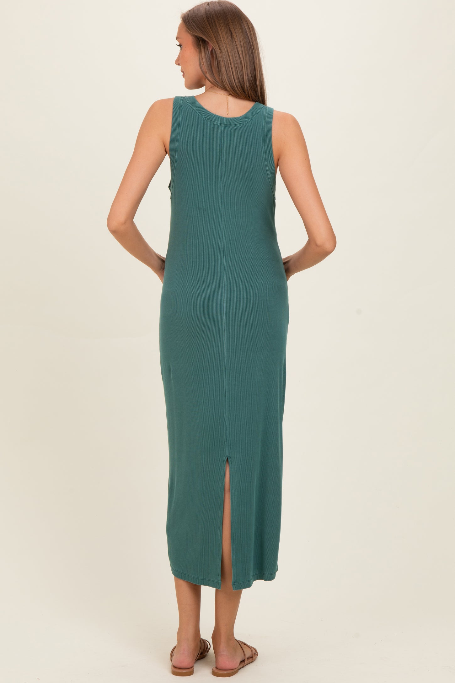 woman wearing a teal sleeveless maternity maxi dress with a thigh-high slit at the back
