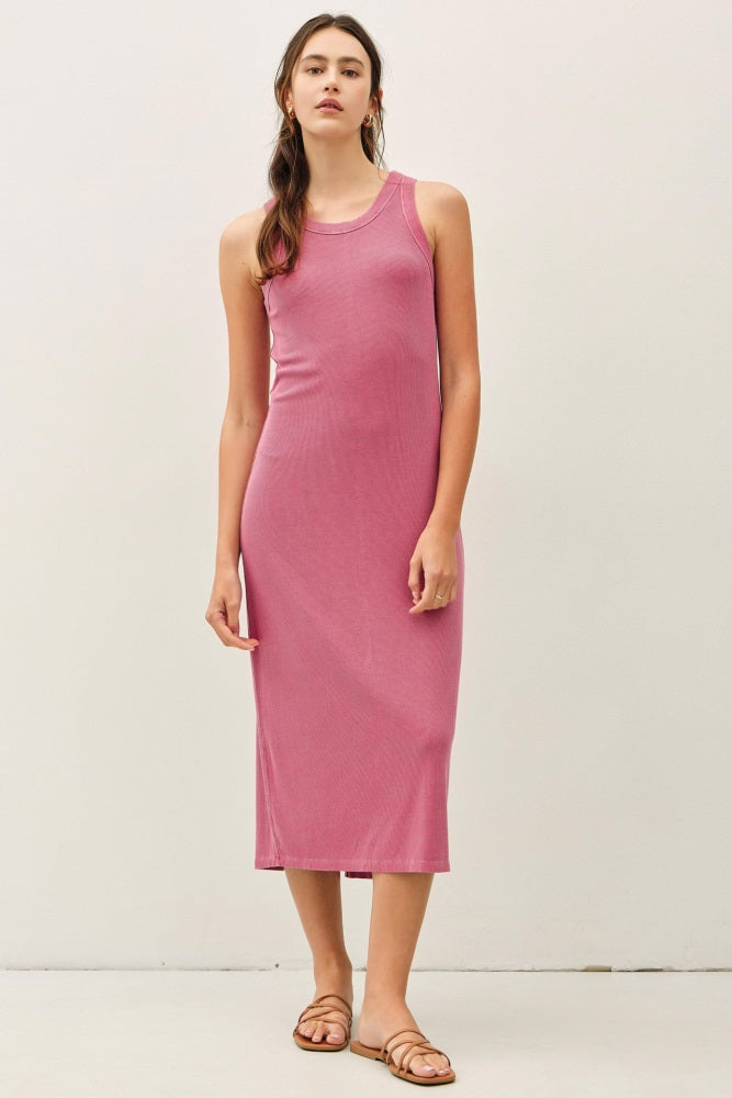 woman wearing a pink sleeveless ribbed maxi dress with a fitted silhouette and standing against a neutral background