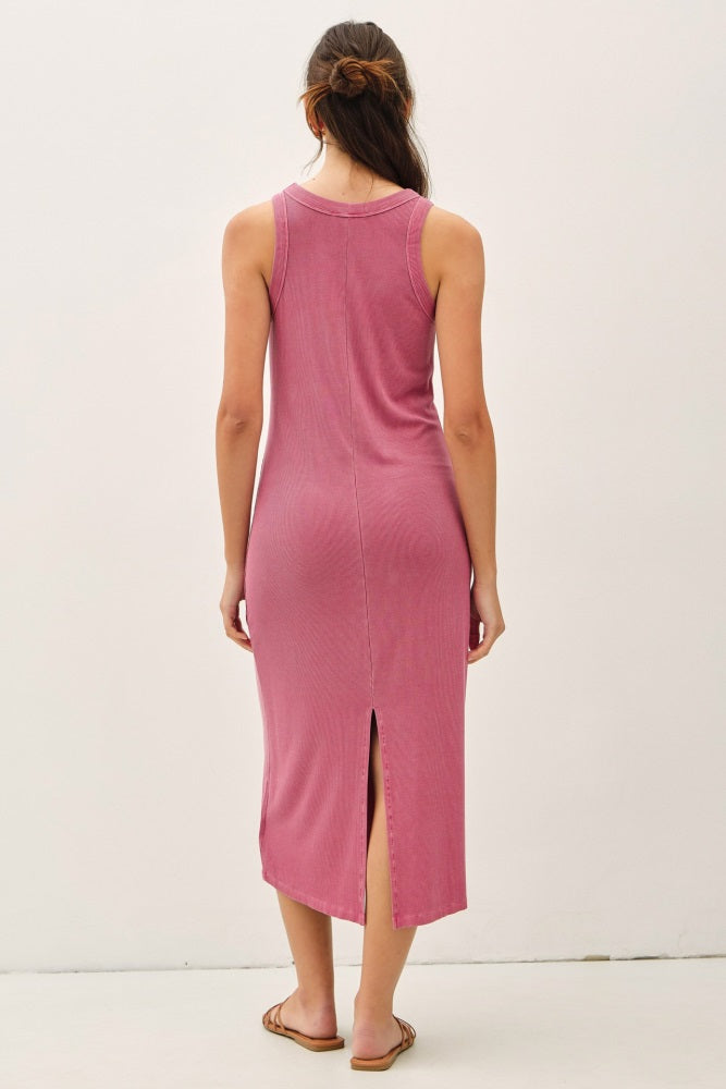woman wearing a pink sleeveless midi dress with a back slit and a relaxed fit