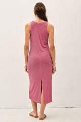 woman wearing a pink sleeveless midi dress with a back slit and a relaxed fit