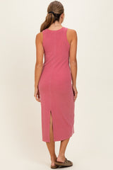 woman wearing a rose pink sleeveless midi dress with a back slit detail