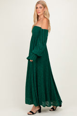 woman wearing a green off-the-shoulder lace maxi dress with long sleeves and a flowy skirt