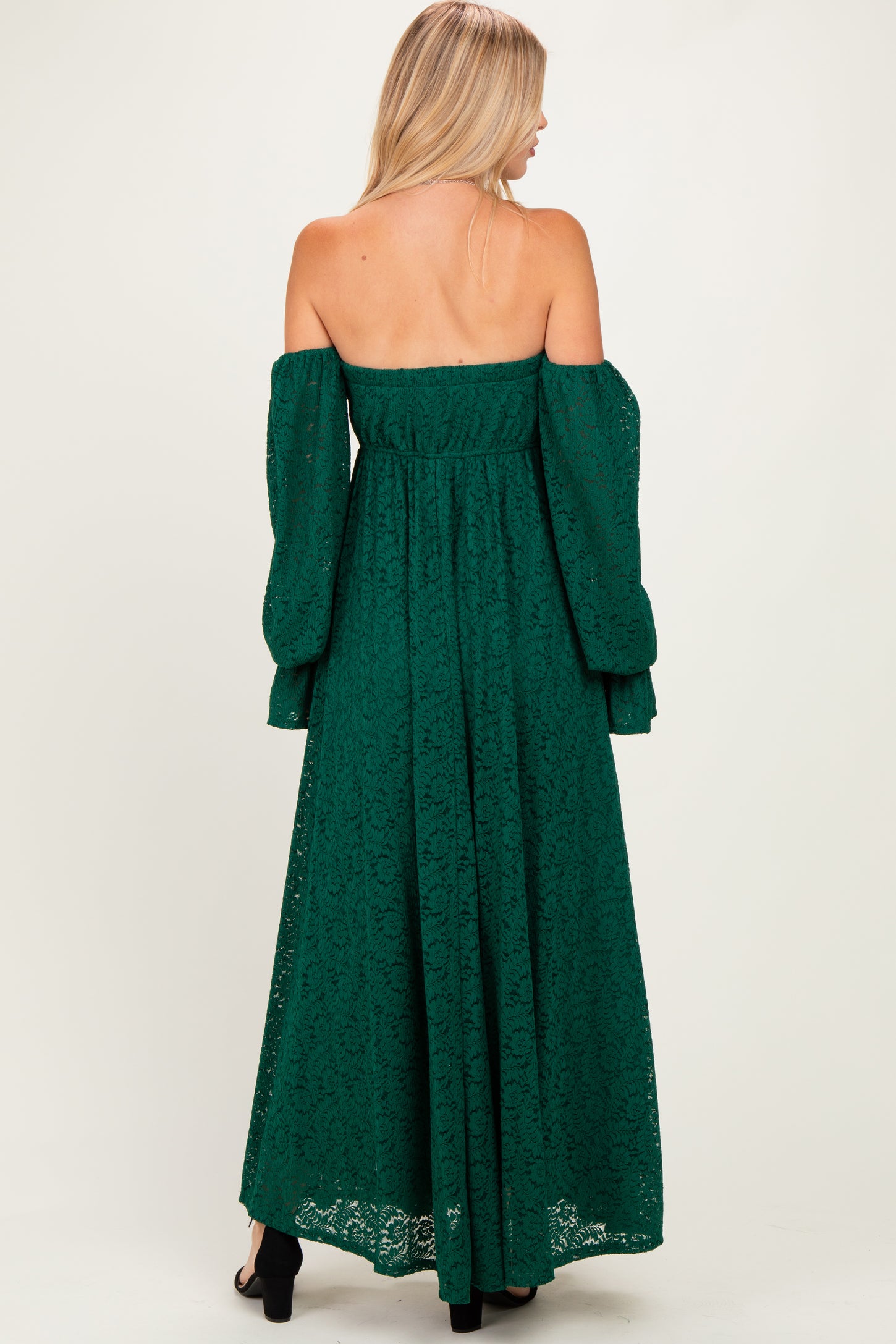 woman wearing a green off-the-shoulder maxi dress with long puff sleeves and lace detailing, shown from the back