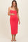 woman wearing a hot pink maternity dress with spaghetti straps and a visible baby bump