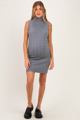 woman wearing a gray sleeveless maternity dress with a high neck and ribbed texture, showcasing her baby bump