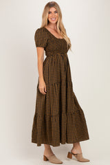 woman wearing a brown and black gingham print maxi dress with puff sleeves and tiered skirt