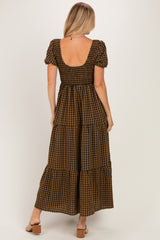 woman wearing a brown and black gingham maxi dress with puff sleeves and a smocked back design