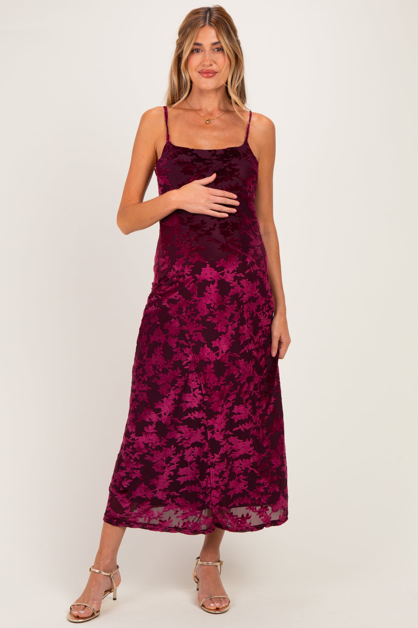 woman wearing a burgundy floral lace maternity dress with adjustable spaghetti straps and a baby bump visible