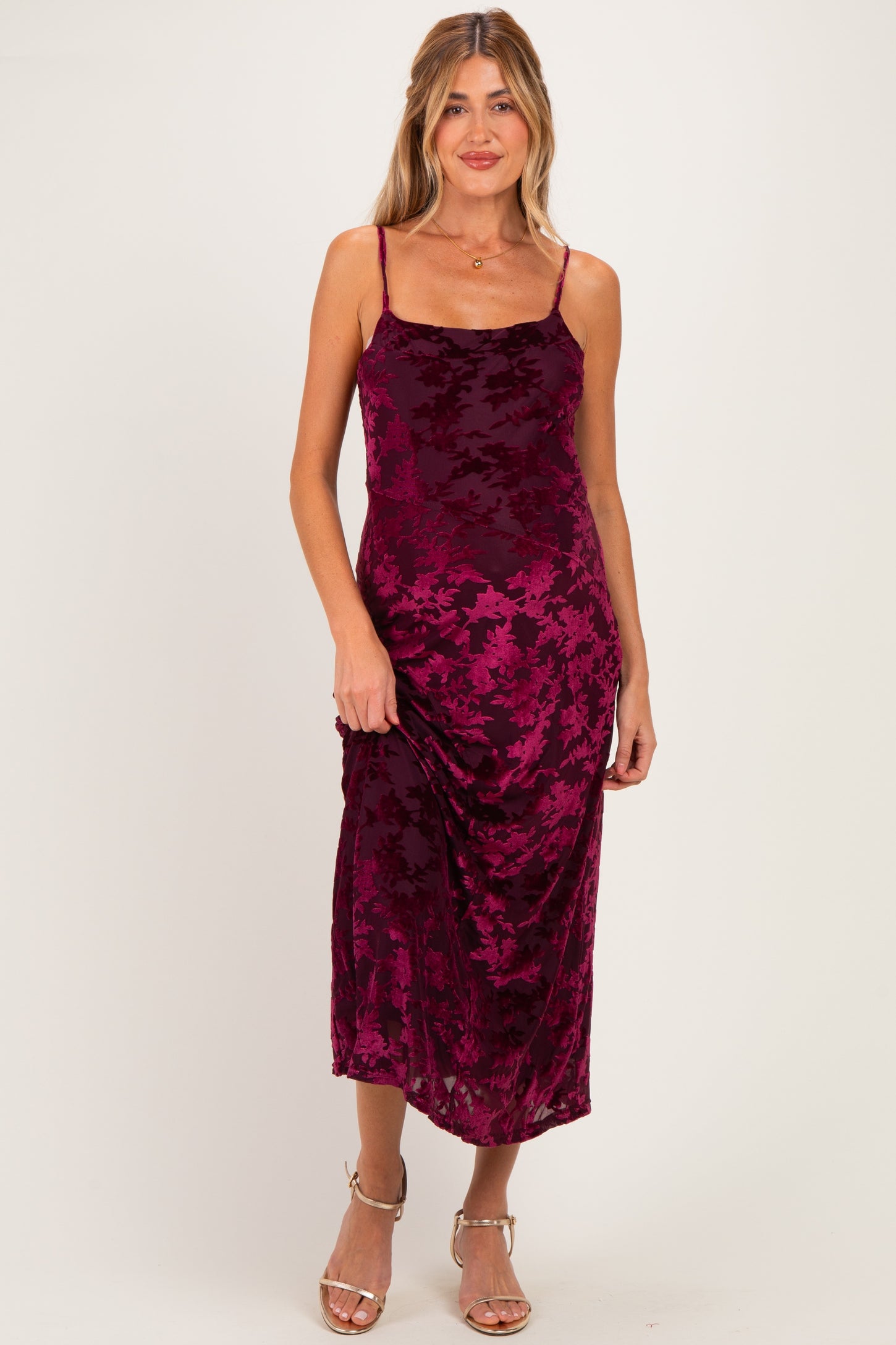 woman wearing a burgundy floral print maternity dress with spaghetti straps and a fitted silhouette