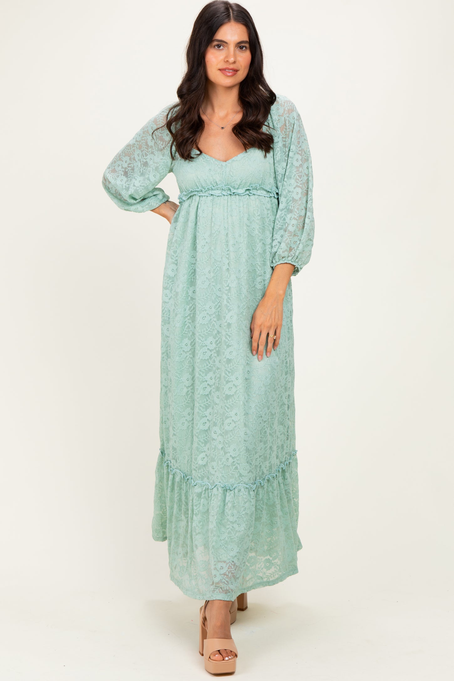woman wearing a light mint green maxi dress with puff sleeves and a ruffled hem