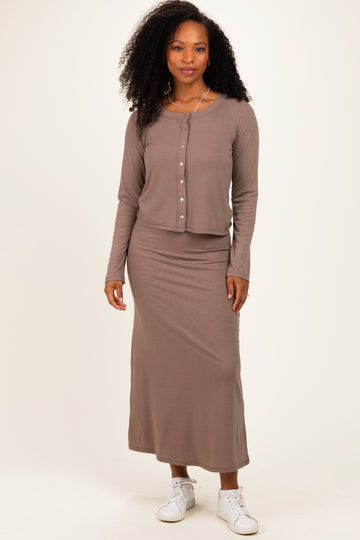 woman wearing a taupe ribbed two-piece outfit with a button-up top and long skirt, paired with white sneakers