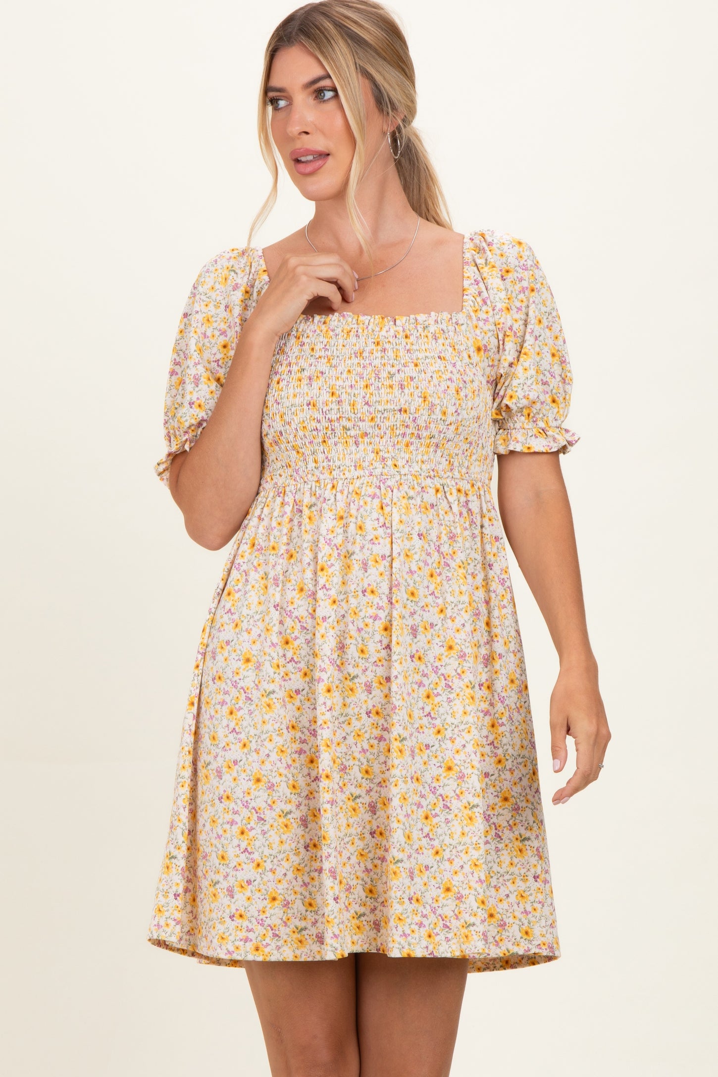 woman wearing a short floral smock dress with puff sleeves and a square neckline