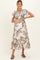 woman wearing a maternity floral print maxi dress with ruffle hem and holding her baby bump
