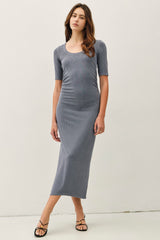 woman wearing a gray ribbed midi dress with short sleeves and a scoop neckline, paired with strappy sandals