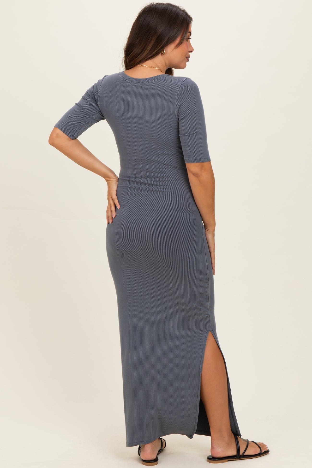 woman wearing a gray ribbed maternity maxi dress with short sleeves and side slits, showing her baby bump