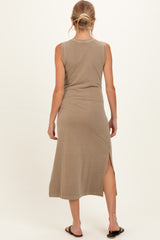 woman wearing a light brown sleeveless maternity maxi dress with side slits, showcasing a relaxed fit and casual style