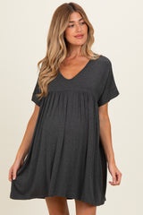 woman wearing a dark gray short-sleeve maternity dress with a flowy hem and a baby bump visible