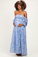 woman wearing a light blue floral maternity maxi dress with a strapless design and puff sleeves, showing her baby bump