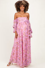 woman wearing a pink floral off-the-shoulder maternity dress with long sleeves and a visible baby bump
