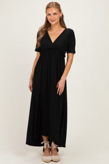 woman wearing a black short sleeve maxi dress with a v-neck and gathered waistline