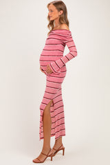 woman wearing a pink and white striped off-shoulder maternity dress with side slit and holding her baby bump