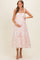 woman wearing a floral print maternity maxi dress with bow straps and holding her baby bump